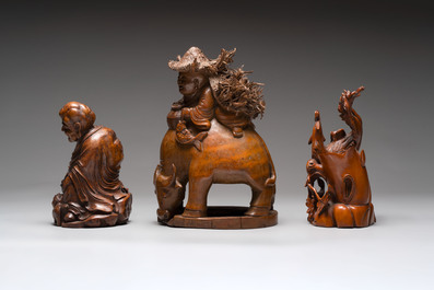 Three Chinese carved bamboo figures and a boxwood carving of a phoenix, 20th C.