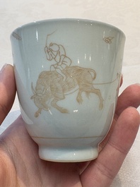 A Chinese iron-red-decorated 'boy and buffalo' cup and saucer and a famille rose 'Xi Xiang Ji' cup and saucer, Qianlong
