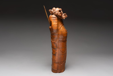 Three Chinese carved bamboo figures and a boxwood carving of a phoenix, 20th C.