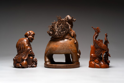 Three Chinese carved bamboo figures and a boxwood carving of a phoenix, 20th C.