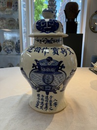 A Chinese blue and white vase and cover with calligraphy and antiquities, 19th C.