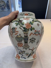 A Chinese famille verte covered vase, a pair of blue and white jars on wooden stands and two jars, 19th C.