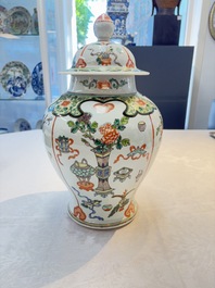 A Chinese famille verte covered vase, a pair of blue and white jars on wooden stands and two jars, 19th C.