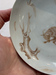 A Chinese iron-red-decorated 'boy and buffalo' cup and saucer and a famille rose 'Xi Xiang Ji' cup and saucer, Qianlong