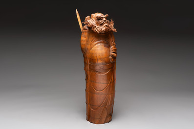 Three Chinese carved bamboo figures and a boxwood carving of a phoenix, 20th C.