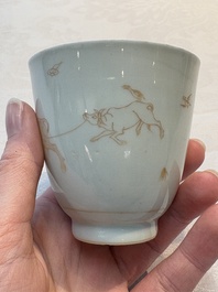 A Chinese iron-red-decorated 'boy and buffalo' cup and saucer and a famille rose 'Xi Xiang Ji' cup and saucer, Qianlong