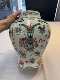 A Chinese famille verte covered vase, a pair of blue and white jars on wooden stands and two jars, 19th C.
