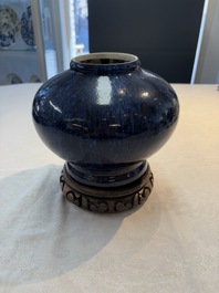 A Chinese flamb&eacute;-glazed vase on wooden stand, 19th C.