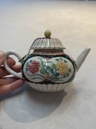 A Chinese famille rose black-ground teapot and stand with floral design, Yongzheng/Qianlong