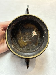 A Chinese archaistic bronze censer with a wooden cover, Xuande mark, 19th C.
