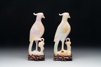 A pair of Chinese lavender and emerald-green jadeite parrots on wooden stands, 19th C.