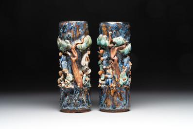 A pair of Chinese Shiwan polychrome hat stands with haut-relief figural design, 19/20th C.