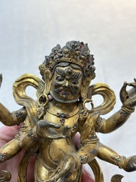 A Sino-Tibetan gilt-bronze figure of White Mahakala on wooden stand, 18th C.
