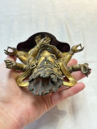 A Sino-Tibetan gilt-bronze figure of White Mahakala on wooden stand, 18th C.