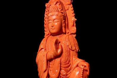 A fine Chinese red coral sculpture of Guanyin seated on a lotus throne on a wooden stand, 19/20th C.