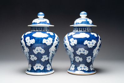 A pair of Chinese blue and white covered vases with floral design, 19th C.