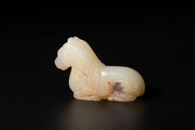 A Chinese white and russet jade pendant in the form of a horse, Song/Ming