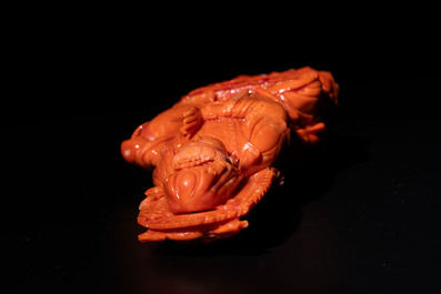 A fine Chinese red coral sculpture of Guanyin seated on a lotus throne on a wooden stand, 19/20th C.