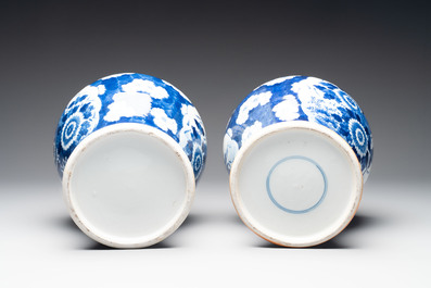 A pair of Chinese blue and white covered vases with floral design, 19th C.