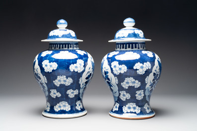 A pair of Chinese blue and white covered vases with floral design, 19th C.