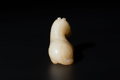A Chinese white and russet jade pendant in the form of a horse, Song/Ming
