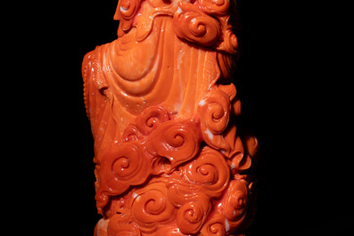 A fine Chinese red coral sculpture of Guanyin seated on a lotus throne on a wooden stand, 19/20th C.