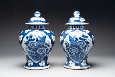 A pair of Chinese blue and white covered vases with floral design, 19th C.