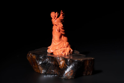 A Chinese red coral sculpture of a Milefo Buddha on wooden stand, 19/20th C.