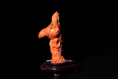 A Japanese red coral sculpture of a fisherman on wooden stand, 19/20th C.