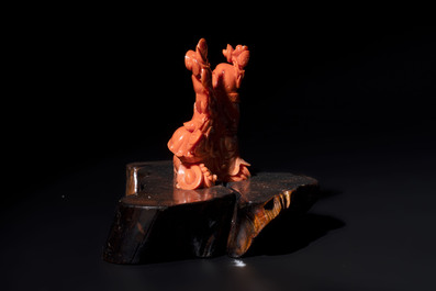 A Chinese red coral sculpture of a Milefo Buddha on wooden stand, 19/20th C.