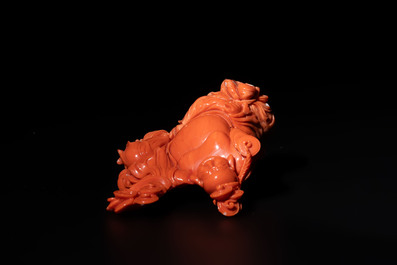 A Chinese red coral sculpture of a Milefo Buddha on wooden stand, 19/20th C.