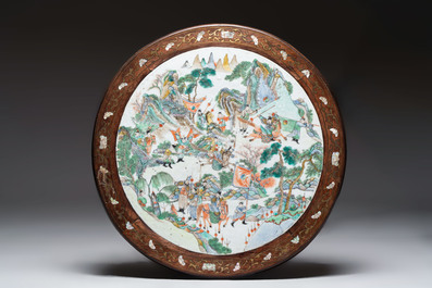 A Chinese mother-of-pearl-inlaid hongmu table with a circular Canton famille verte 'warriors on horseback' plaque, 19th C.