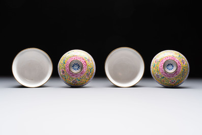 A pair of Chinese yellow-ground Canton enamel covered bowls and two cups, Yongzheng/Qianlong