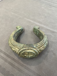 A bronze mirror, a bracelet with a royal or noble emblem and a bronze bracelet with two tiger heads, Cambodia, 12th C.