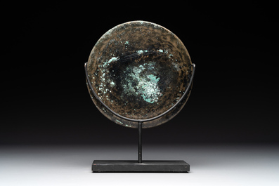 A bronze mirror, a bracelet with a royal or noble emblem and a bronze bracelet with two tiger heads, Cambodia, 12th C.