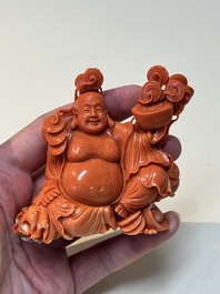 A Chinese red coral sculpture of a Milefo Buddha on wooden stand, 19/20th C.