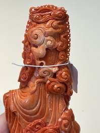 A fine Chinese red coral sculpture of Guanyin seated on a lotus throne on a wooden stand, 19/20th C.