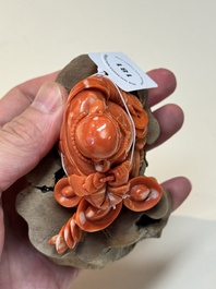 A Chinese red coral sculpture of a Milefo Buddha on wooden stand, 19/20th C.