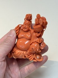A Chinese red coral sculpture of a Milefo Buddha on wooden stand, 19/20th C.