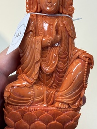 A fine Chinese red coral sculpture of Guanyin seated on a lotus throne on a wooden stand, 19/20th C.