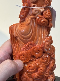 A fine Chinese red coral sculpture of Guanyin seated on a lotus throne on a wooden stand, 19/20th C.