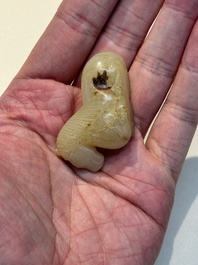 A Chinese white and russet jade pendant in the form of a horse, Song/Ming