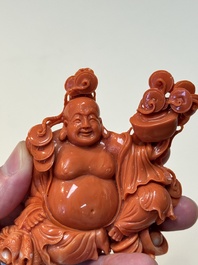 A Chinese red coral sculpture of a Milefo Buddha on wooden stand, 19/20th C.
