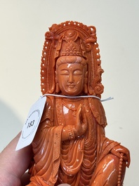 A fine Chinese red coral sculpture of Guanyin seated on a lotus throne on a wooden stand, 19/20th C.