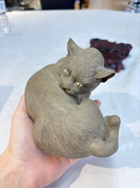 A Chinese Shiwan stoneware cat on a wooden stand, 20th C.