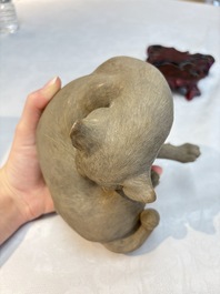 A Chinese Shiwan stoneware cat on a wooden stand, 20th C.