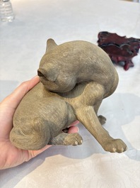 A Chinese Shiwan stoneware cat on a wooden stand, 20th C.