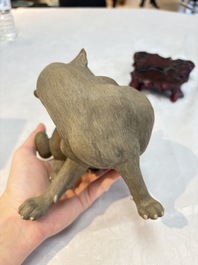 A Chinese Shiwan stoneware cat on a wooden stand, 20th C.