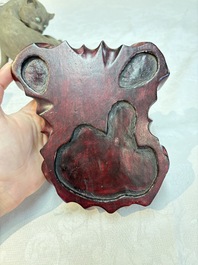 A Chinese Shiwan stoneware cat on a wooden stand, 20th C.