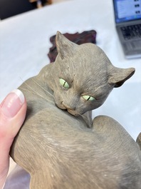 A Chinese Shiwan stoneware cat on a wooden stand, 20th C.